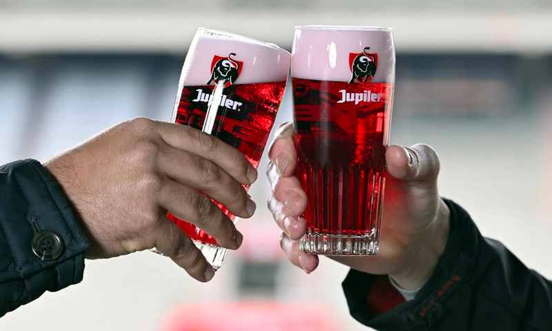 Mannen proosten met Jupiler in het rood in glas